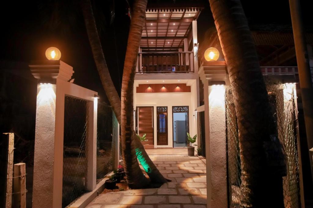 a walkway leading to a house at night at Arunella Beach Villa in Tangalle