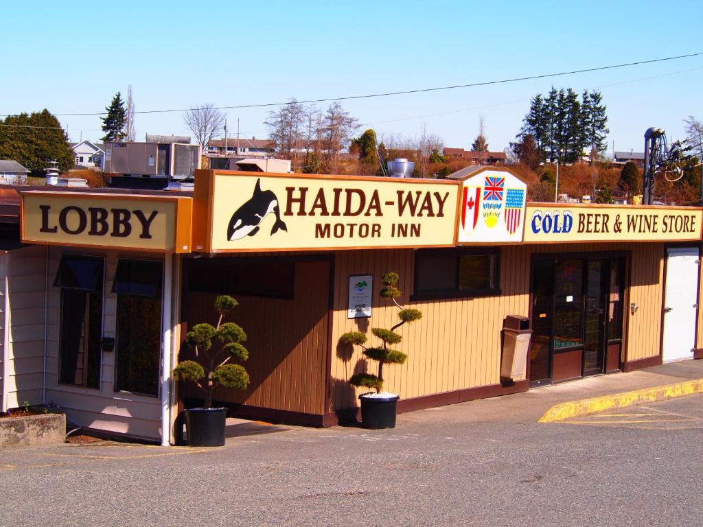 a building with a sign for a dog shop at Haida Way Motor Inn in Port McNeill