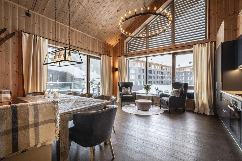 a living room with a table and chairs and a large window at Fyri Tunet Hemsedal in Hemsedal