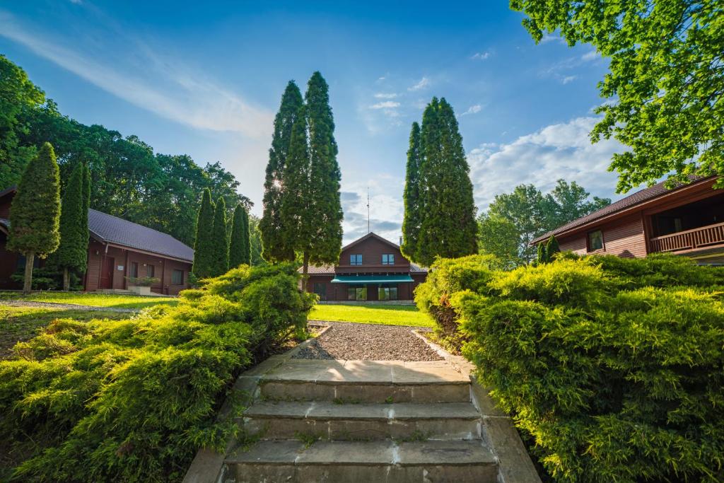 a garden with a stone path leading to a house at Lac Sub Soare in Vărbila