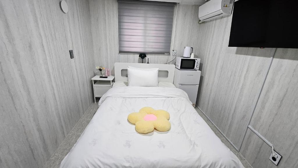 a teddy bear laying on a bed in a room at 루미에르스테이 in Ŭijŏngbu-yŏk