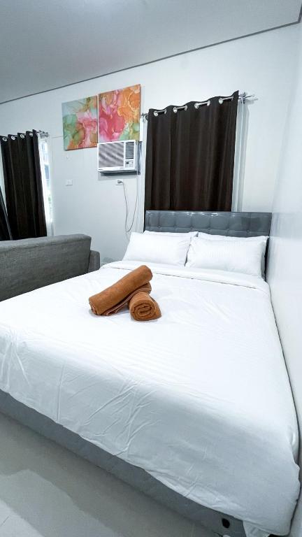 a large white bed with two towels on it at Comfortable Studio Stay Made for Relaxation in Iloilo City