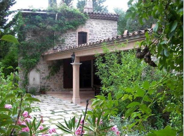 an old stone house with a walkway in a garden at Le Mas du Goïo in Seillans