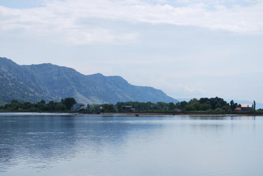 a large body of water with mountains in the background at H and H Guesthouse in Velipojë