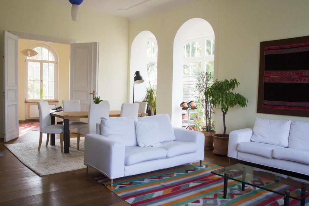 a living room with two white couches and a table at Villa Erica in Teltow