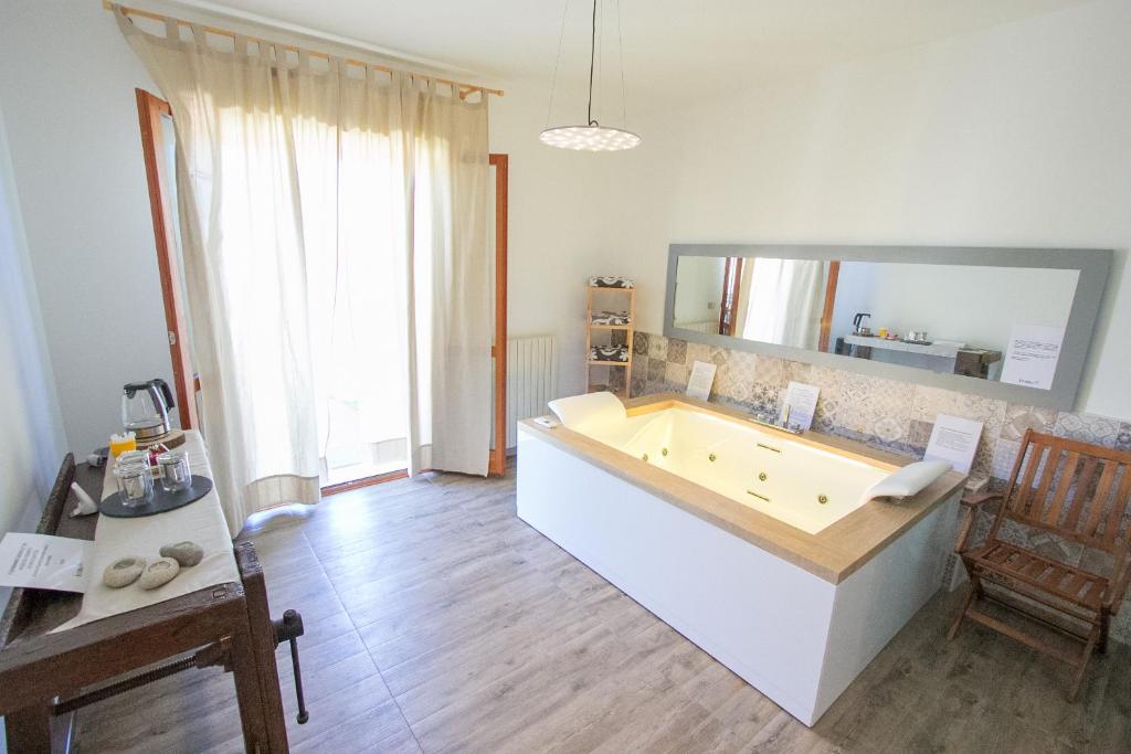a large bathroom with a tub in a room at Le Cromie B&B in Catignano