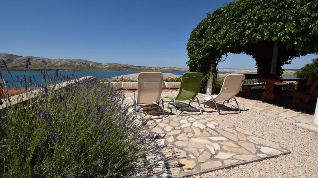 a group of chairs sitting on a patio near the water at Coastal Retreat Villa Milena by Villas Guide in Novalja