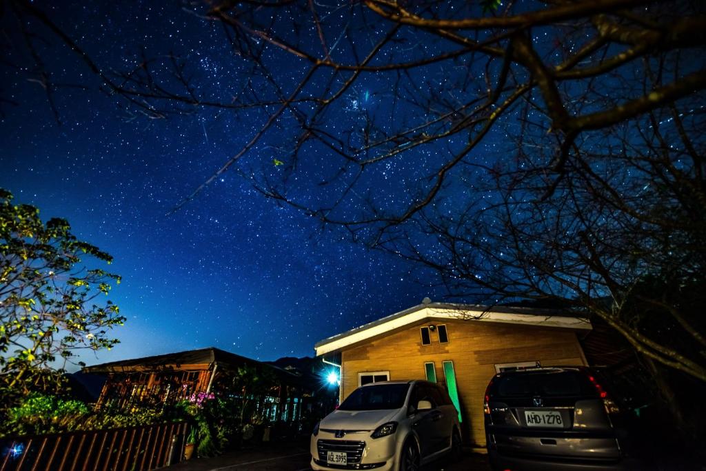 two cars parked in front of a house at night at Natural Residence B&amp;B in Tai&#39;an