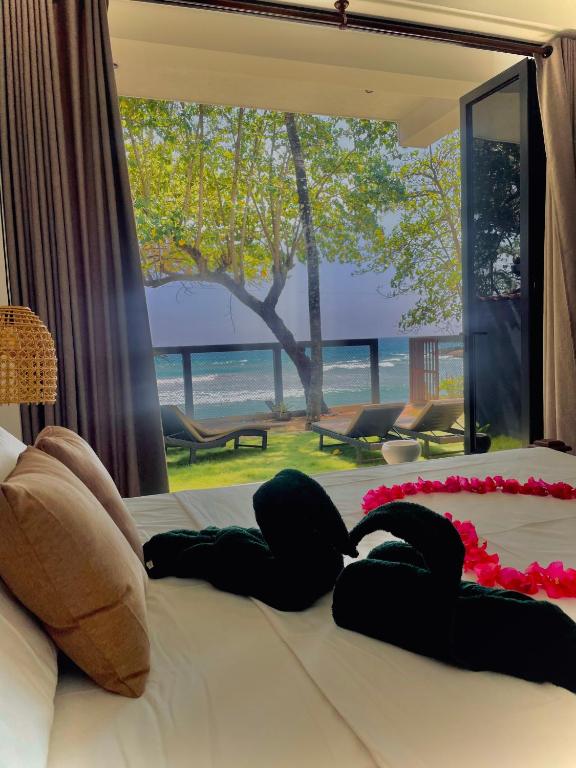 a woman laying on a bed in a bedroom at Bloom Beach Villa in Batigama