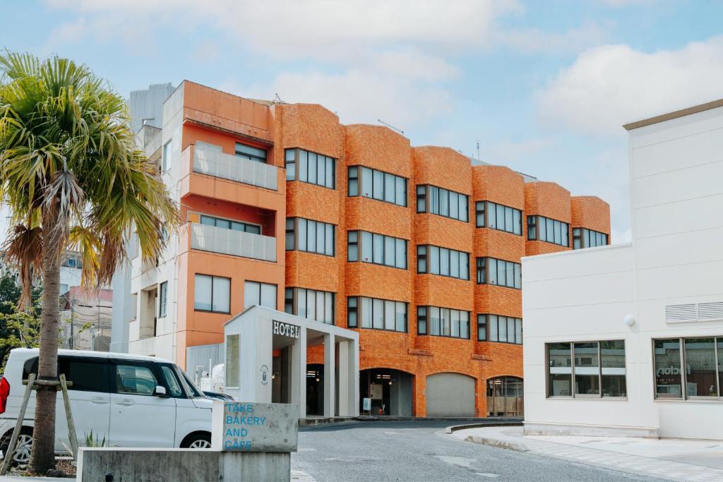 a red brick building with a white truck parked in front of it at KOTOBUKI Hotel in Kanoya