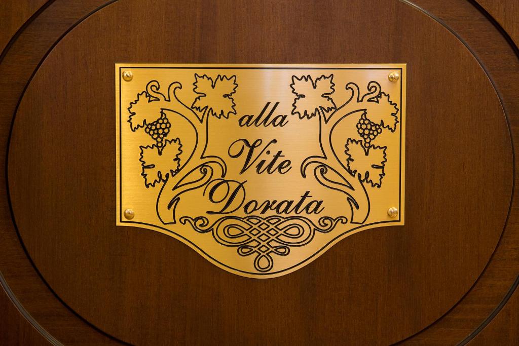 a gold sign on a wooden door with a cite on it at Alla Vite Dorata in Venice