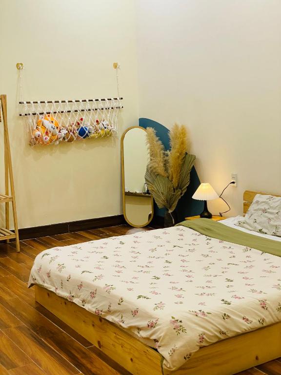a bedroom with a bed and a mirror on the wall at Khế Homestay in Can Tho
