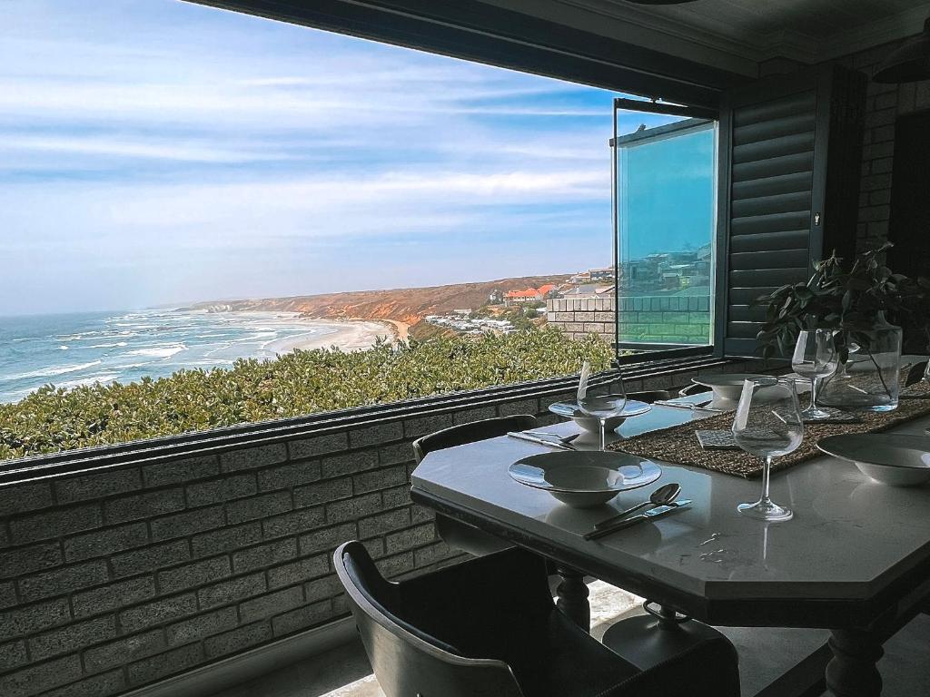a dining room with a table and a view of the ocean at Dolphin View Accomodation in Strandfontein