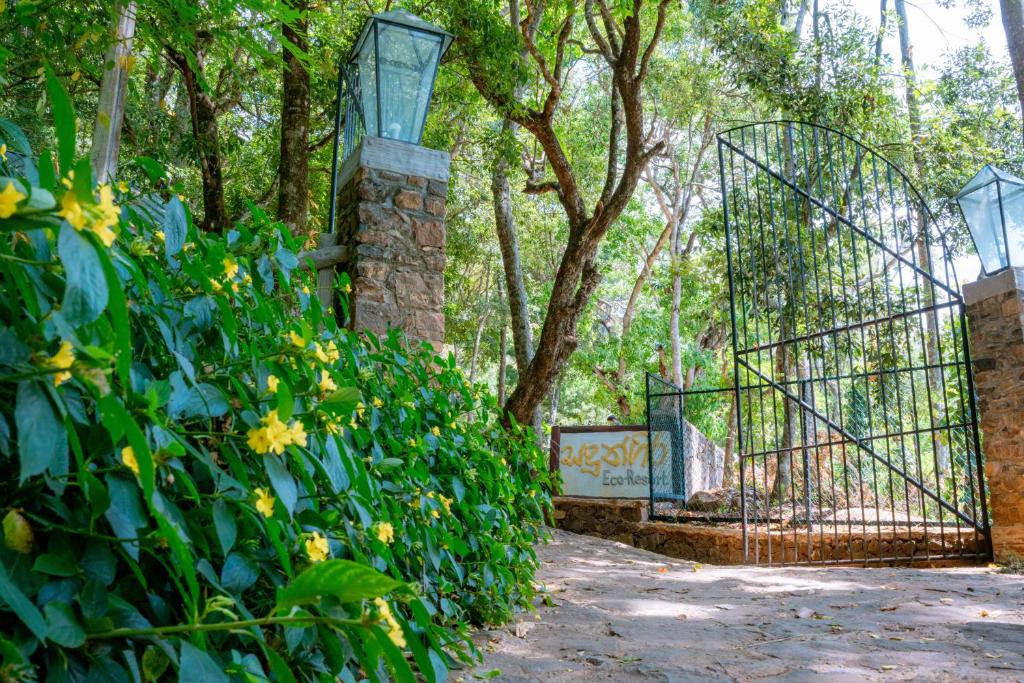 a gate in a garden with yellow flowers at Sandungira Eco Resort in Belihuloya