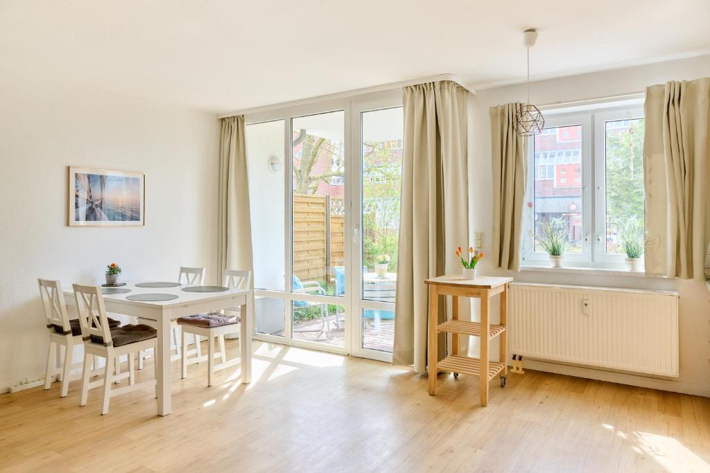 a living room with a table and chairs and a window at Ferienwohnung Sonnendeck Moba-Travel in Priwall