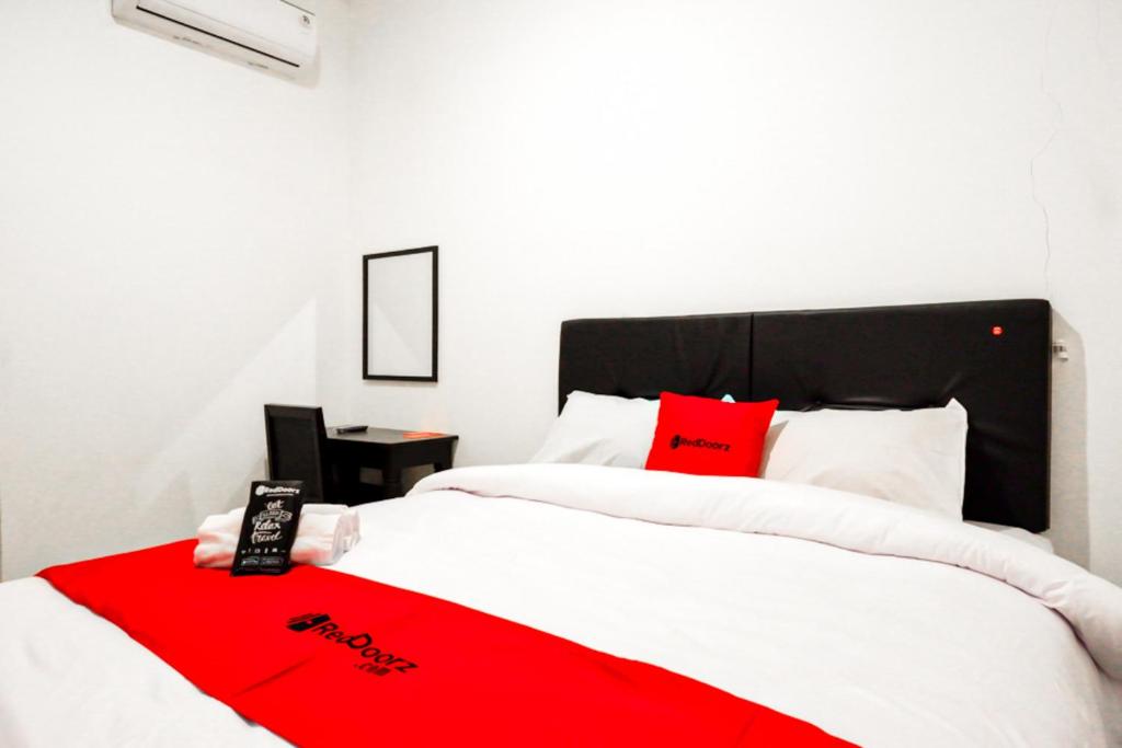 a bedroom with two beds with red pillows at RedDoorz @ Jalan Wonosari KM.9 in Yogyakarta