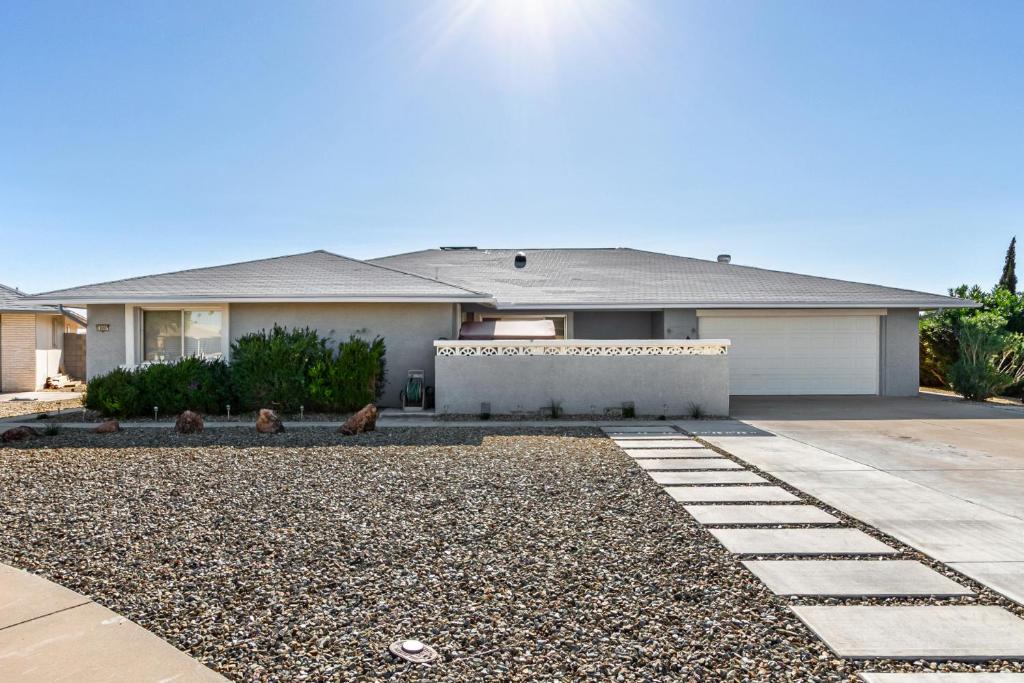 a house with a gravel driveway in front of it at Naturally Modest & Quiet in Sun City West