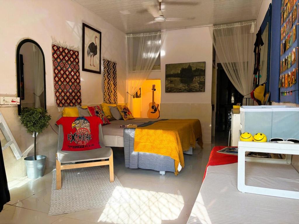 a bedroom with a bed with a yellow blanket at Sun Bloom in Mumbai