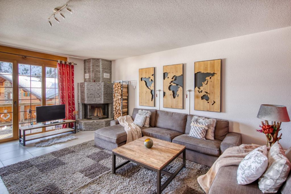 a living room with a couch and a table at Ski-in Ski-out with Chimney and view in Les Crosets