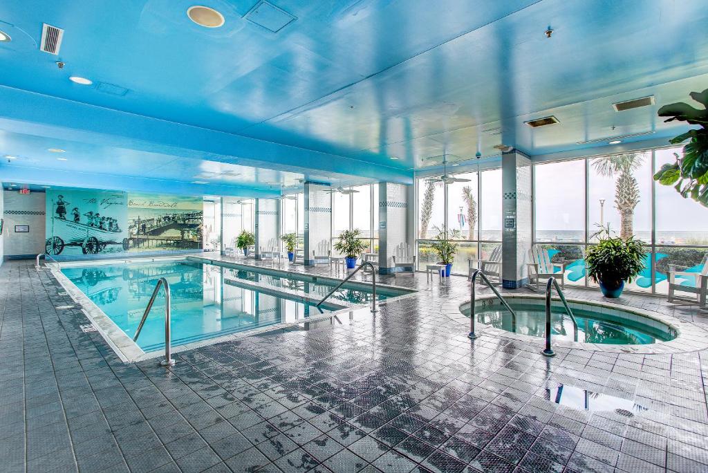 a large swimming pool in a building with windows at Boardwalk Resort and Villas in Virginia Beach