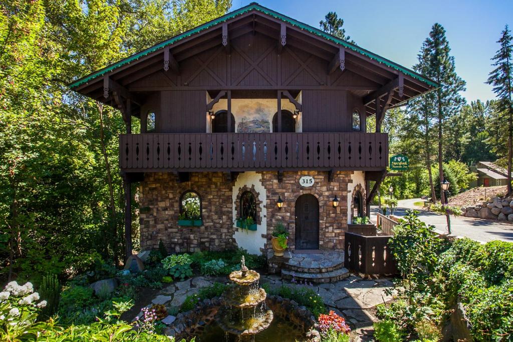 a house with a balcony on top of a garden at Storybook Riverside Inn in Leavenworth