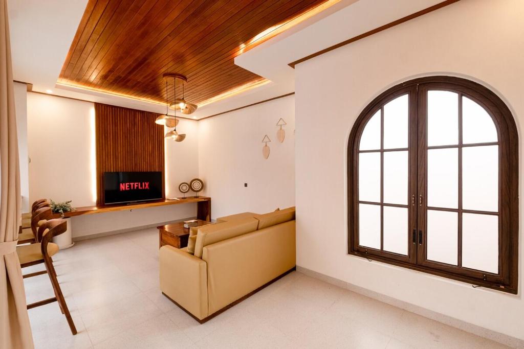 a living room with a couch and a window at Green Mutiara Jimbaran in Jimbaran