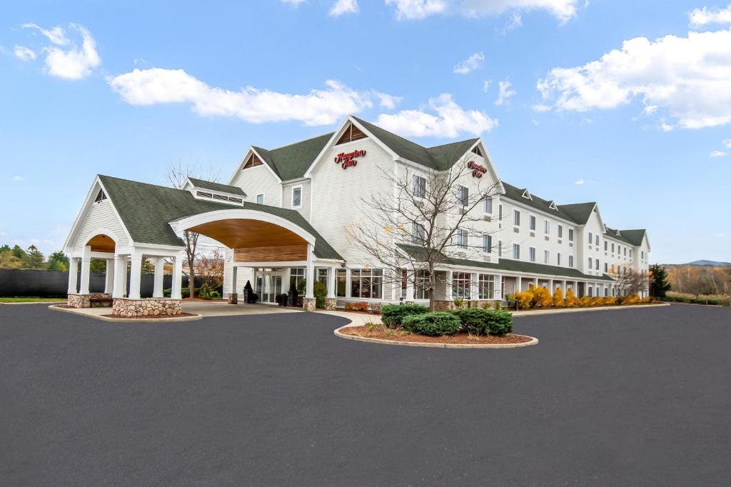 a large white building with a large driveway at Hampton Inn Rutland/Killington in Rutland