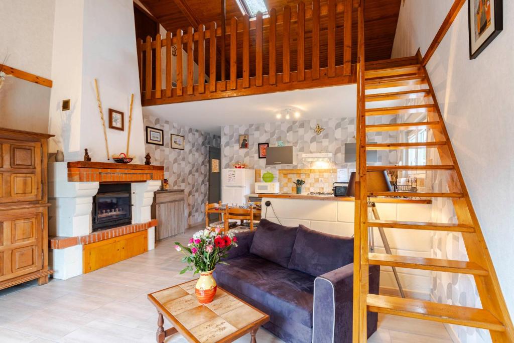 a living room with a couch and a wooden staircase at Gîte Lavand Cottage À Brantôme in Brantôme
