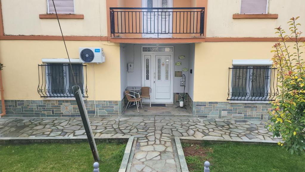 a front door of a house with a balcony at Αυλή της Ελιάς in Prosotsáni