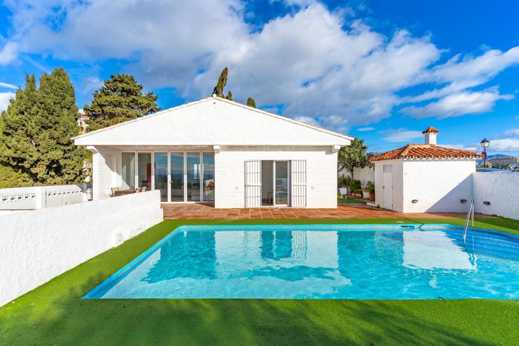 a villa with a swimming pool in front of a house at Casa Green in Mijas Costa