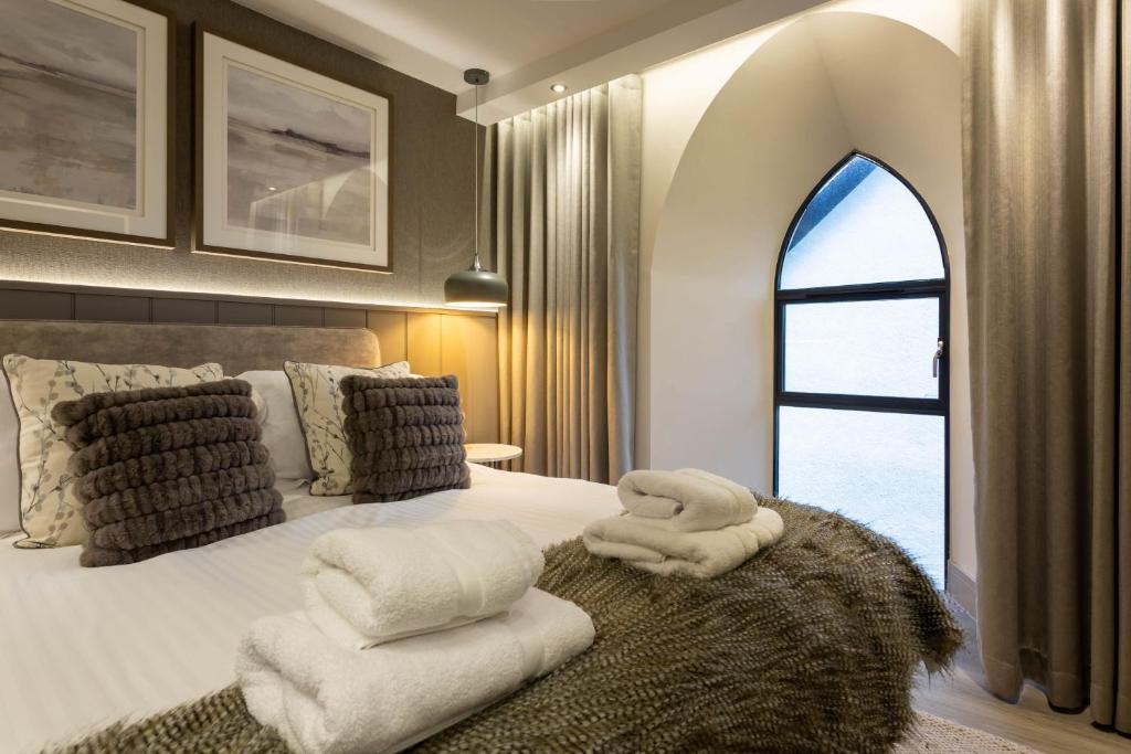 a bedroom with a bed with white towels on it at Arran Shores Luxury Shorefront Apartment 3 in Lamlash