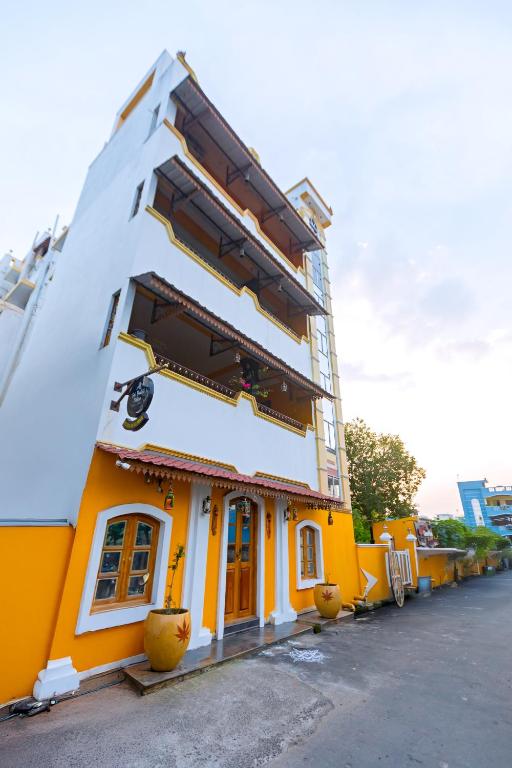 a building with a yellow and white building at Sri Balaji Villas Pondicherry with Car Parking in Pondicherry