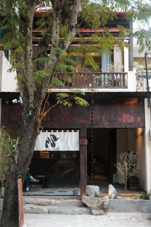 a building with a balcony and a tree at ZenHome by M2 in Hoi An