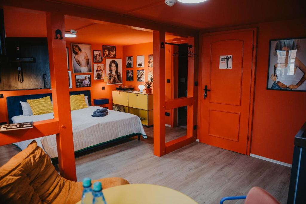 a bedroom with orange walls and a bed and a desk at sleepArt music in Celle