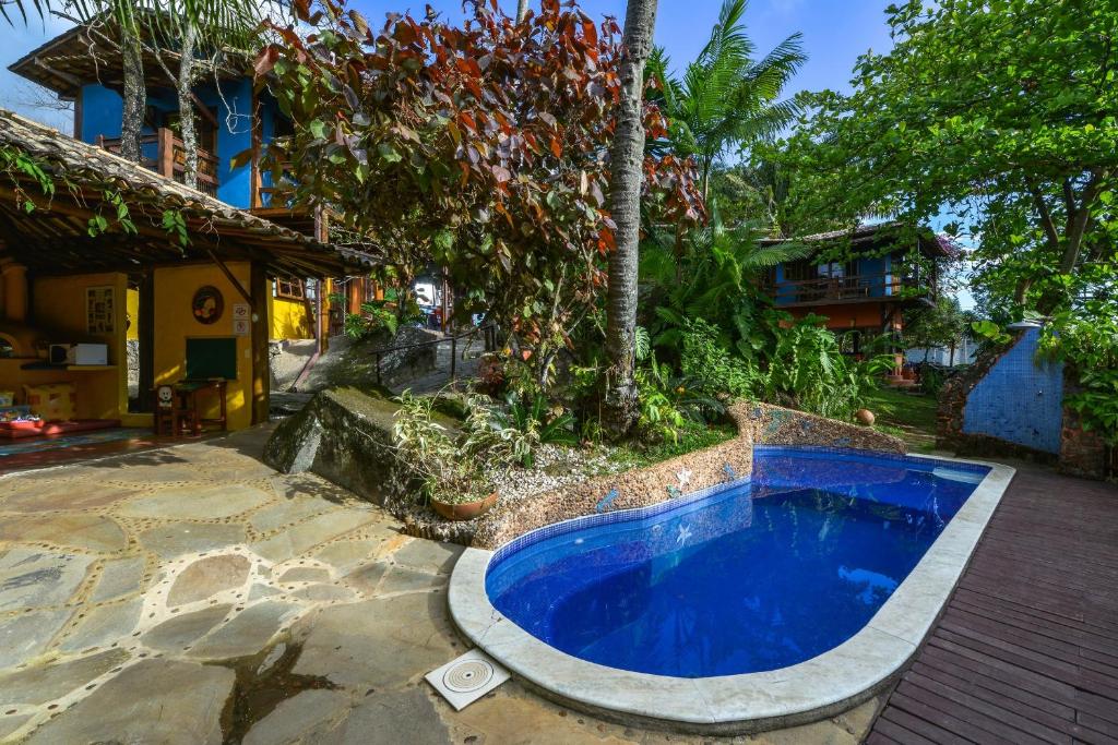 uma pequena piscina azul num quintal ao lado de um edifício em Pousada Villa Da Prainha em Ilhabela