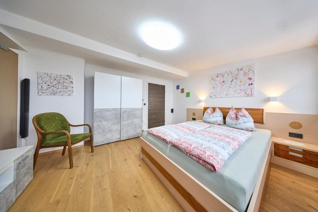 a bedroom with a large bed and a chair at Apartment Wenger Leogang in Leogang