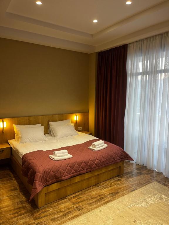 a bedroom with a bed with two towels on it at Seven Rooms Hotel in Tbilisi City