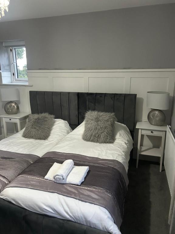 two beds in a room with towels on them at Meadow View in Alfreton