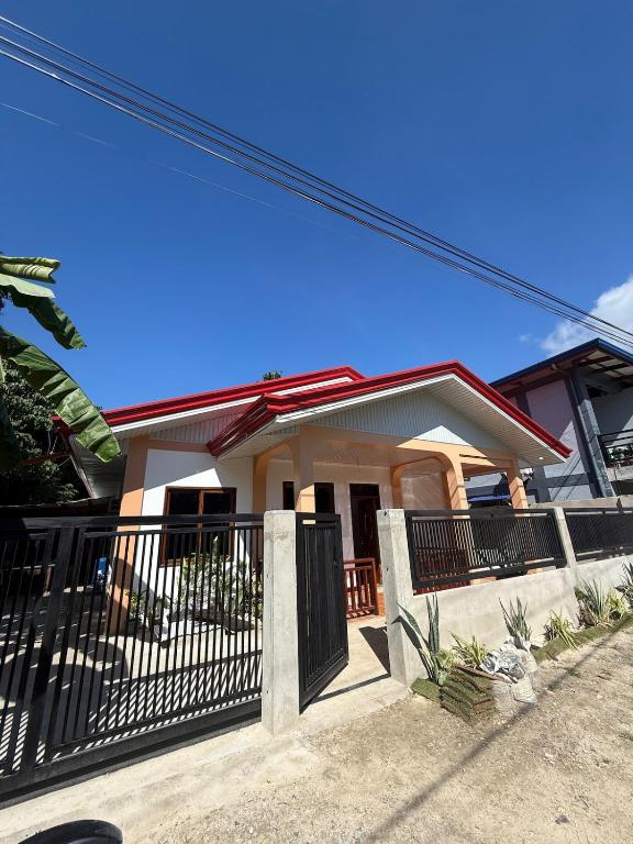 a house with a black fence and a gate at Bayakyak Soie Residence in General Luna
