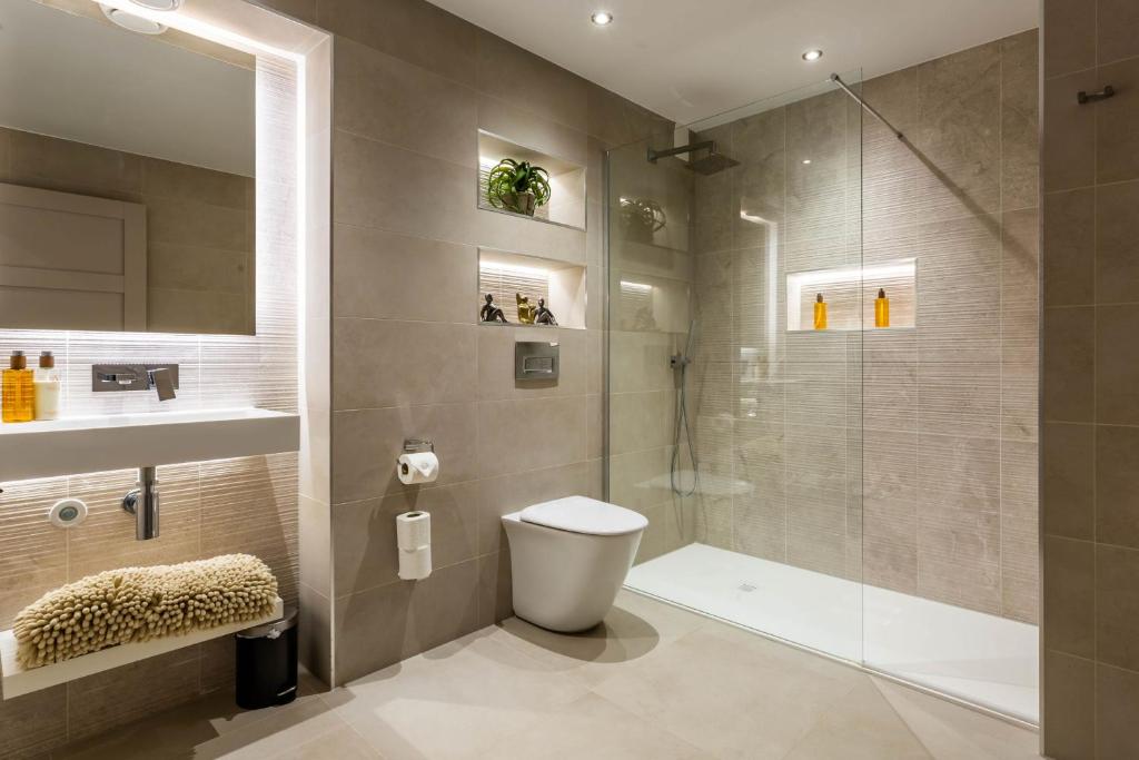 a bathroom with a shower and a toilet and a sink at Arran Shores Luxury Shorefront Garden Terrace Apartment 6 in Lamlash