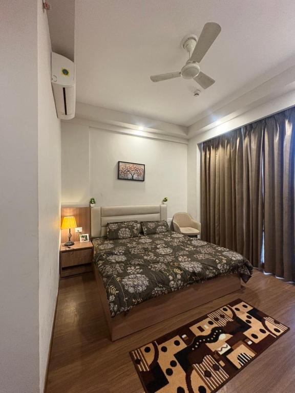 a bedroom with a bed and a ceiling fan at Omaxe Air B&B in Greater Noida