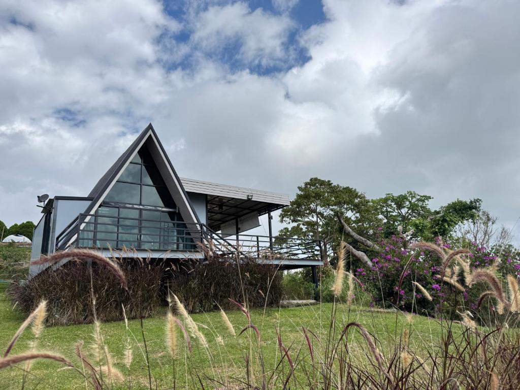 a house with a triangular roof on top of a field at Freedom home khaokho in Khao Kho