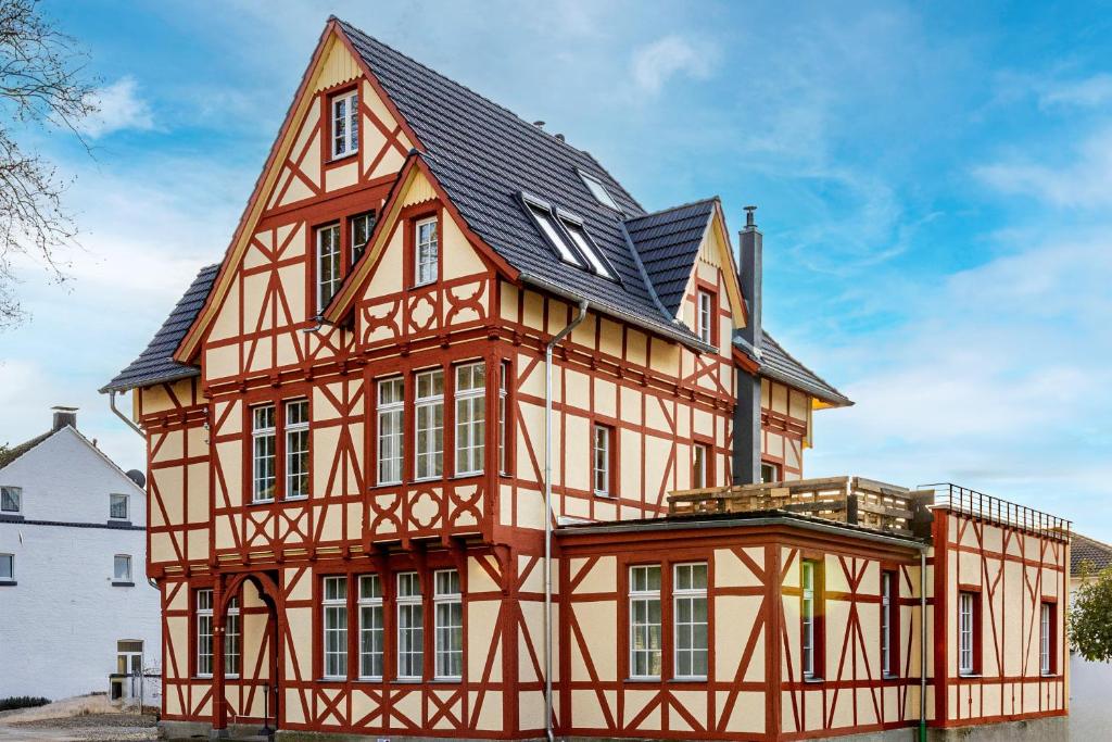 an orange and yellow house with a black roof at Mariene Home Apartments - Am Hammer in Rösrath