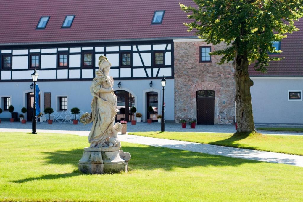 uma estátua na relva em frente a um edifício em Pałac Łagów - Hotel em Zgorzelec