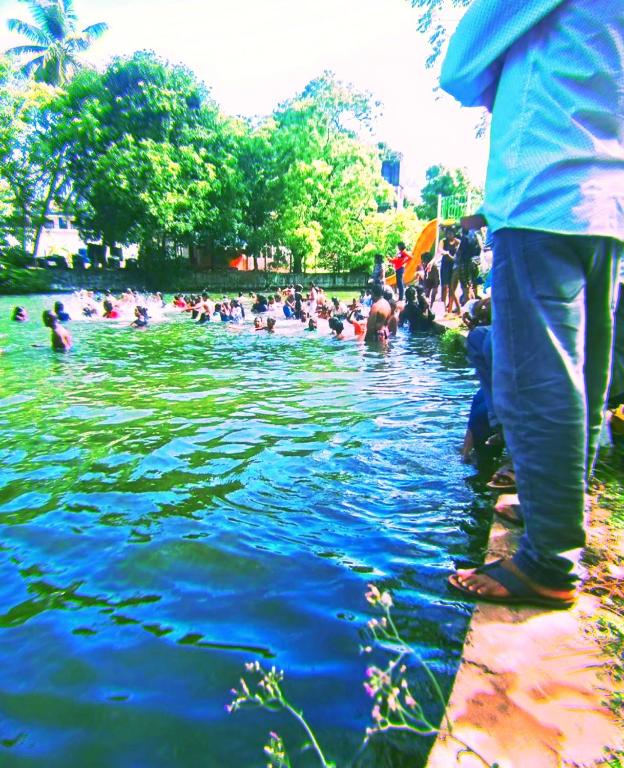a crowd of people in the water at a park at Parakum Rest Rooms in Polonnaruwa