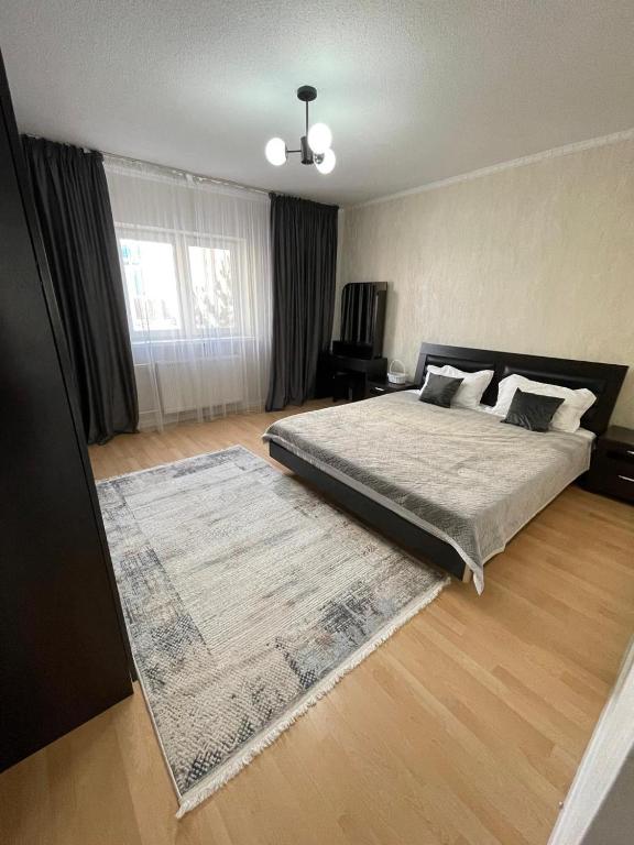 a bedroom with a large bed and a rug at RentHouse Samal in Astana