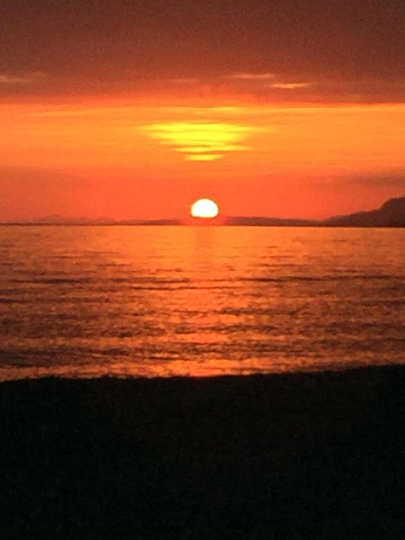 un tramonto su un corpo d'acqua con il sole di Attico Tacito a Ventimiglia