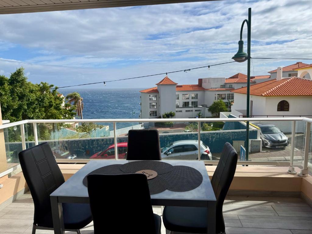 a table and chairs on a balcony with a view of the ocean at Seaview Suite in Caniço