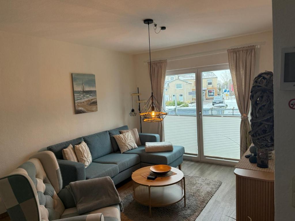 a living room with a blue couch and a table at Apartment Alleestraße in Büsum