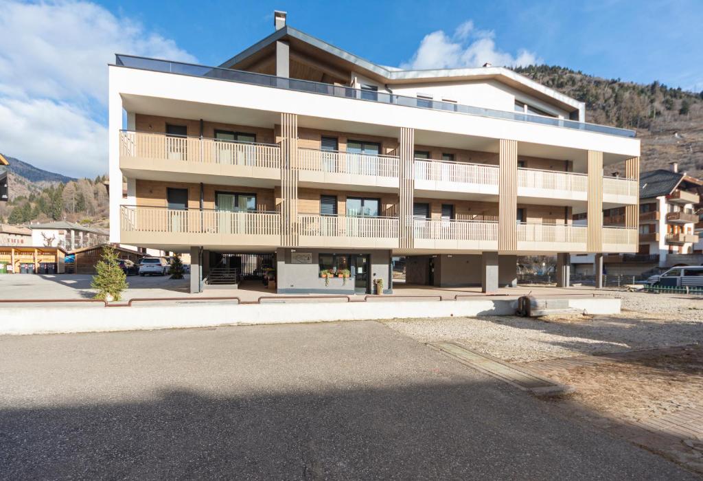 a large building with a parking lot in front of it at Vacanze la Malga in Predazzo